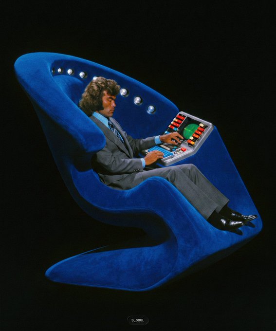 A man in a gray suit sits reclined in a futuristic blue chair while operating a complex control panel with colorful buttons and a green monitor. The image humorously depicts an overly elaborate, sci-fi styled "throne" being used to send transactions to the SXT (Space and Time) chain, suggesting the tooling feels unnecessarily complex or futuristic.