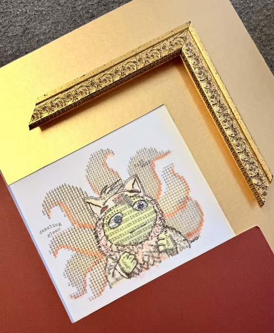 An art print of a cat with money overlaid on its face displayed under an ornate gold corner frame on a yellow and orange backdrop.