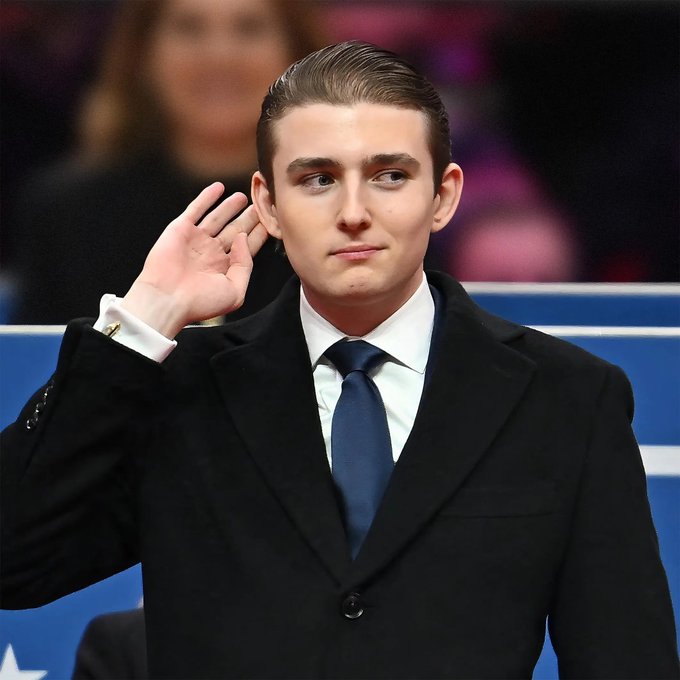 Image 5 shows Barron Trump in a black coat, white shirt, and dark blue tie, holding his hand up to his ear as if listening, with a blurred background showing blue and pink hues.