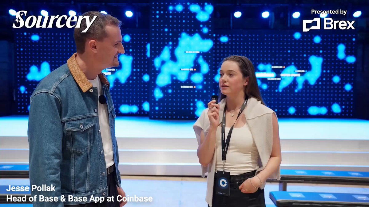 The image features a man wearing a blue denim jacket and a woman holding a microphone, standing next to each other with their backs to the camera. They are positioned behind a screen that displays an advertisement for Sourcery. The text "It' s kind of funny that Hyperliquid gets flak for not being decentralized but Base (and L2s) are just single servers Mechanically, they're not that much different from the New York Stock Exchange" is written on the image. This statement seems to be a reference to the content of the post by Sourcery and the comparison between the centralized server model used in Hyperliquid and the more decentralized server models found at the New York Stock Exchange.