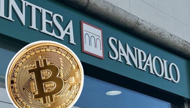 A Bitcoin coin is superimposed over the exterior signage of Intesa Sanpaolo bank.