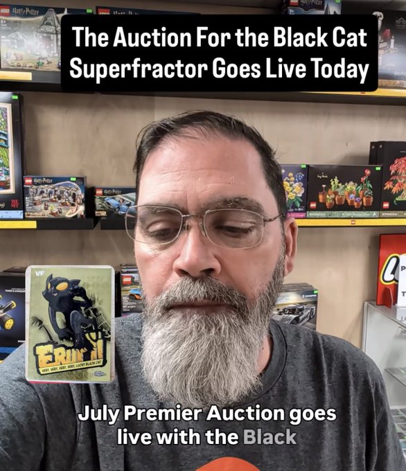 Video thumbnail showing a bearded man with glasses in a Lego store, with text announcing 'The Auction For the Black Cat Superfractor Goes Live Today' and 'July Premier Auction goes live with the Black', featuring a Black Cat trading card overlay.