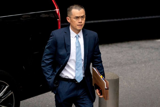 A man in a dark suit and light blue tie, holding a folder, exits a black vehicle, appearing to be arriving at a legal or business setting. This image likely depicts a professional involved in the High Court proceedings mentioned in the post, where Binance and its leadership are being sued by nearly 1,700 individuals in London.