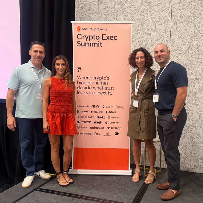 Four people posing in front of a banner reading 'Secures presents Crypto Exec Summit' with the tagline 'Where crypto's biggest names decide what trust looks like next ft.' and logos for companies like Zerobash, Rain, Ledger, Kraken, and Coinbase.