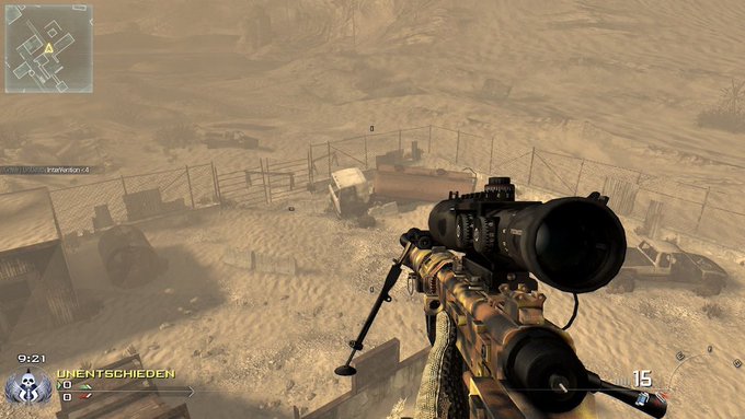 A first-person perspective screenshot from a military shooter video game, showing the player aiming down the scope of a sniper rifle in a dusty desert environment with buildings and vehicles below. The HUD displays 'UNENTSCHIEDEN' (German for 'tied'), a minimap, and a timer of 9:21.