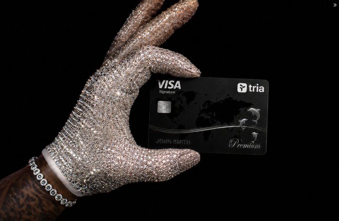 The image shows a hand holding a Visa credit card with a black background. The text "Visa Premium" is visible, indicating that the card is from Visa's premium rewards program. This suggests that the person holding the card might be interested in taking advantage of the benefits offered by the premium rewards program or simply prefers using this particular card for their transactions.