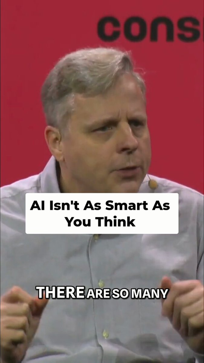 The image features a man wearing a white shirt, with his hands up as if he's speaking or gesturing. The caption below him reads "AI isn't As Smart As You Think. There are so many." This statement seems to be related to an AI-related topic and is accompanied by a red background that makes the text stand out.
