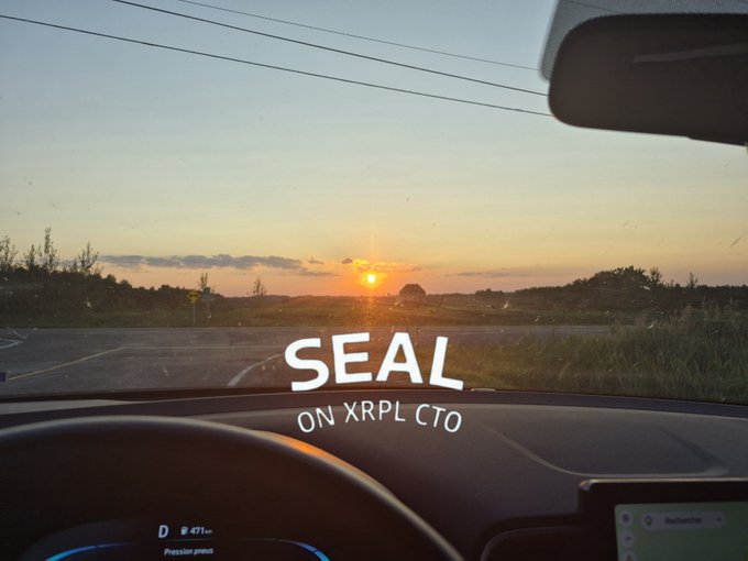 View from inside a car at sunset with the text 'SEAL ON XRPL CTO' overlaid on the dashboard.
