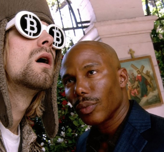 The image shows a man in bitcoin sunglasses next to a man with a mustache in a suit, standing in front of a religious painting of Jesus carrying the cross. This visual pairs perfectly with the post about @baseapp "cooking up something big," drawing a parallel between faith in religion and faith in crypto—suggesting a near-religious devotion to believing in Base's upcoming developments despite lacking proof.