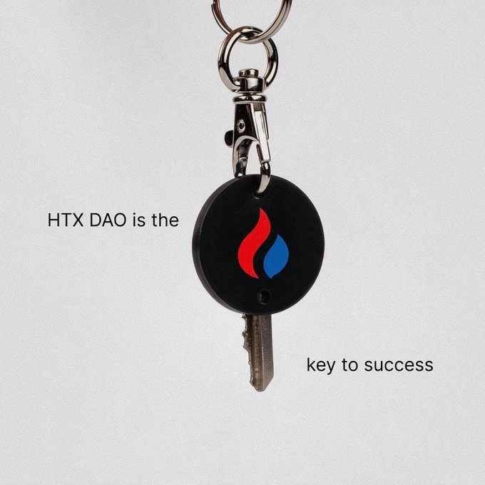 A black keychain with a red and blue flame logo, featuring the text "HTX DAO is the" on the left and "key to success" on the right.