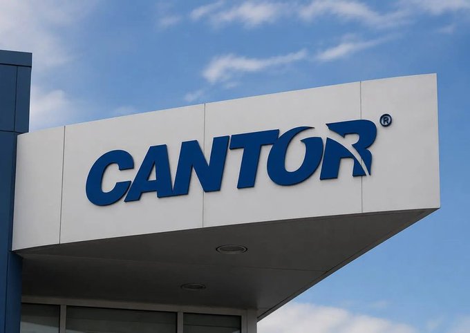 Exterior sign of a building displaying the 'CANTOR' logo in blue letters against a white background under a cloudy blue sky.