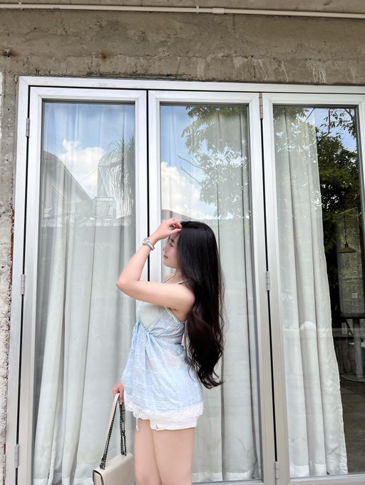 iced tea with a white rim, blue and white floral top, and white shorts are displayed on a table against a gray wall.