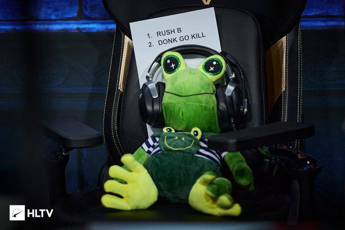 A green Pepe the Frog plushie wearing headphones sits in a gaming chair with a note reading "1. RUSH B 2. DONK GO KILL," referencing CS:GO memes, while the HLTV logo appears in the corner—tying into the $FROG token post about a gaming-focused meme coin.