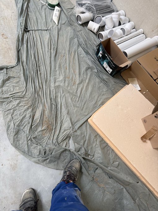 The image shows a person's feet standing on a gray tarp or sheet of plastic covering something on the ground. The person appears to be wearing blue jeans, which are visible from their perspective. The background reveals several boxes scattered around, indicating that they might be in the process of moving or organizing items. The post is about a business called Hustle Stack Usdc/usdt, which could possibly be related to the person's situation if they are involved in some form of construction or organization work.

The image does not provide any specific information about the content of the boxes or their purpose. However, it seems that the person might be preparing for a move or organizing items using the plastic sheeting as a protective covering.