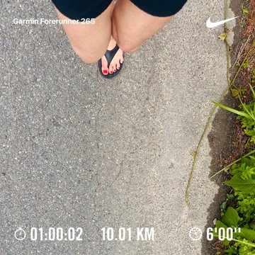 The image shows a person's feet wearing flip flops, walking down a street or sidewalk with a clock showing that they have been walking for 10 minutes at a pace of 6.00 km/h.