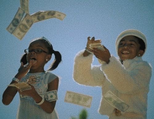 A young girl with pigtails and glasses and a young boy in a white outfit and hat are joyfully throwing dollar bills into the air against a blue sky.
