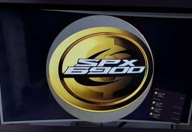 The image shows a television screen displaying the gold and black "SPX 6900" logo, indicating that the SPX 6900 cryptocurrency ticker is being featured on TV, as suggested by the post highlighting its growing mainstream visibility.