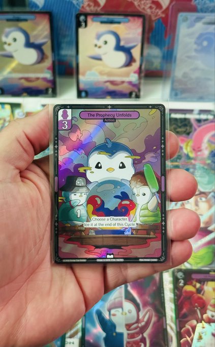 Hand holding a holographic Pudgy Penguins trading card titled 'The Prophecy Unfolds' with text 'Choose a Character. Ice it at the end of the Cycle.' and the number 3.