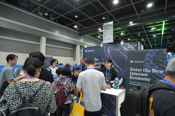 Attendees gather at a convention booth for Injective, which displays the tagline 'Enter the New Internet Economy' for their tokenized stocks and pre-IPO marketplace.