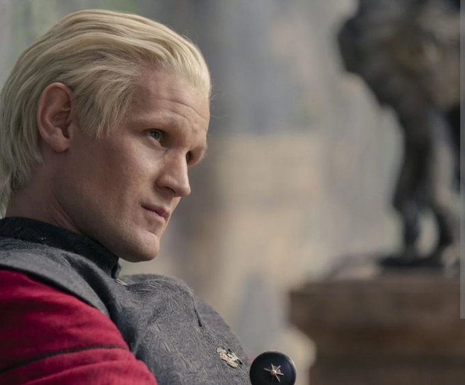 A profile shot of Matt Smith as Daemon Targaryen from House of the Dragon, shown with platinum blonde hair and wearing dark armor.