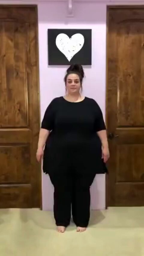 The image features a woman standing in front of two doors, wearing black clothes and posing for a photo. The caption above the image reads "Flirting with fat girl at the gym is like buying Bitcoin in 2008", which seems to be a humorous comparison between the act of flirting and investing in Bitcoin.