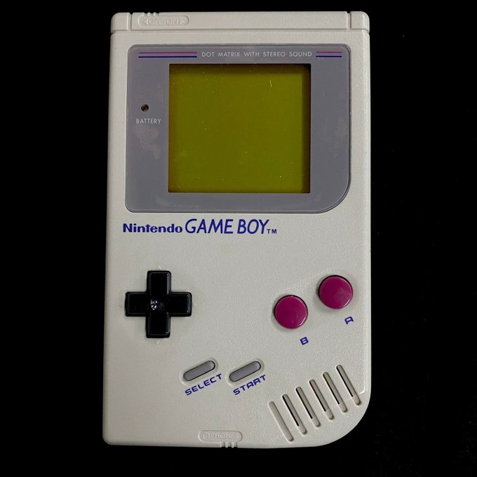 A classic Nintendo Game Boy handheld console with its iconic dot matrix screen and pink A/B buttons rests against a black background, bearing the "Nintendo GAME BOY™" label. The image playfully illustrates the post's nostalgic, self-aware commentary on generational gaming, where the Game Boy symbolizes an "old-school" touchstone that the author embraces while joking about XRP wealth funding a future pilgrimage to Tokyo's Akihabara district.