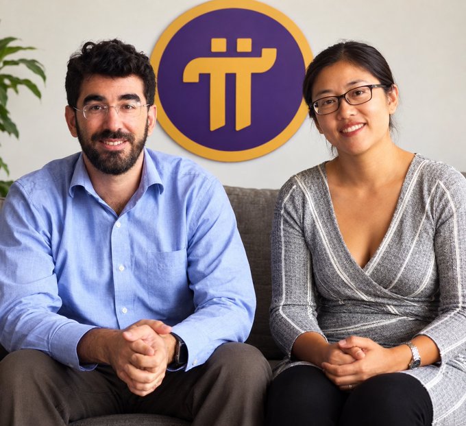 A man in a blue shirt and a woman in a grey dress sit together on a couch, smiling in front of a purple and yellow Pi cryptocurrency logo.