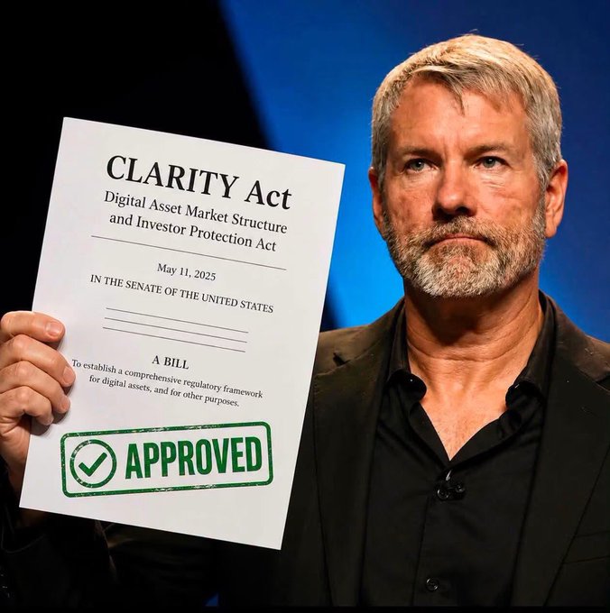Michael Saylor holds up the "CLARITY Act - Digital Asset Market Structure and Investor Protection Act" dated May 11, 2025, stamped with a green "APPROVED" mark, visually reinforcing his public endorsement of the legislation as a milestone for crypto and XRP investors.