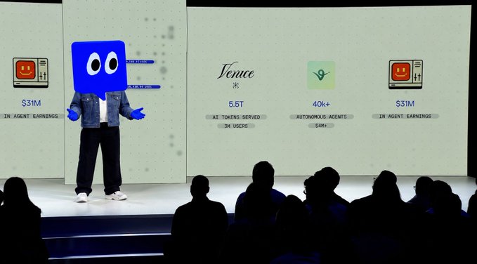In the image, there are two people standing on a stage with a large screen behind them. One of the individuals appears to be wearing a blue costume or suit, while the other person seems to be dressed more formally. The stage has a banner that says "The Base ecosystem is getting a denim upgrade." This suggests that the event might be related to the fashion industry or a promotional campaign for a denim brand.