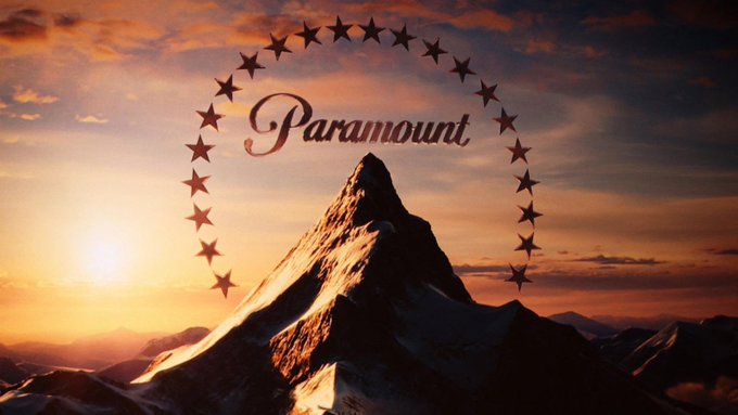 The image features a mountain with a large, circular logo for the movie studio, "Paradigm". The logo consists of a mountain peak surrounded by stars, creating an impressive visual representation of the company's name. The text "Paradigm" is prominently displayed in the center of the logo, and the word "Paradigm" is also written on the bottom right corner of the image.