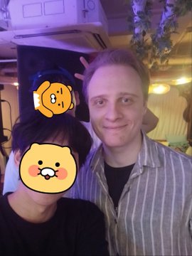 Two men pose for a photo at the Arcium TGE celebration party in Itaewon, Casa Corona, with one holding a glass of beer; the image has cartoon stickers covering the faces. The post expresses excitement about the post-TGE $ARX era and community event.