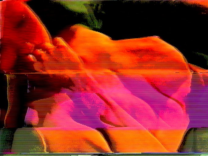 A distorted, glitch-art style image with intense red, orange, and purple hues displaying horizontal scan lines and visual artifacts.
