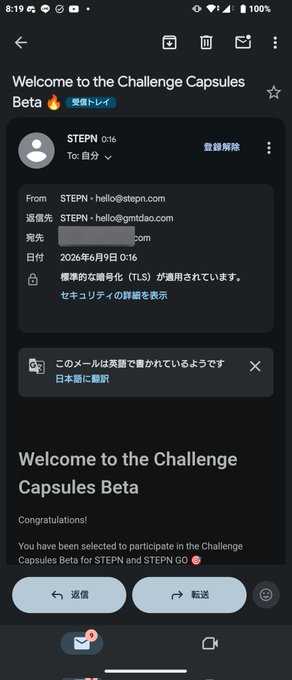 The image shows a phone screen with an email message displayed, which appears to be written in Japanese. The text includes greetings such as "Welcome to the Challenge Capsules beta" and "Congratulations! You have been selected for the challenge". The phone is positioned on top of a table or countertop, suggesting that it might be a personal device being used by someone who has received this email message.