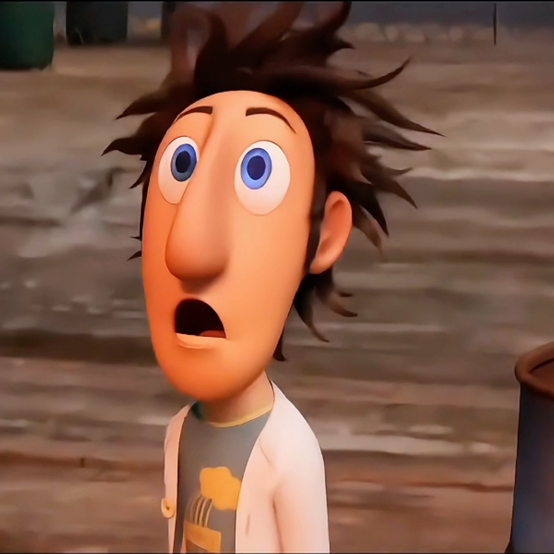 A 3D animated character with messy dark hair, large blue eyes, and a shocked expression with mouth open, wearing a white coat over a graphic t-shirt.