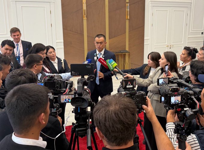 A man in a suit is surrounded by reporters and camera operators during a press conference, with microphones displaying 'VTC' and 'VTC10' logos.