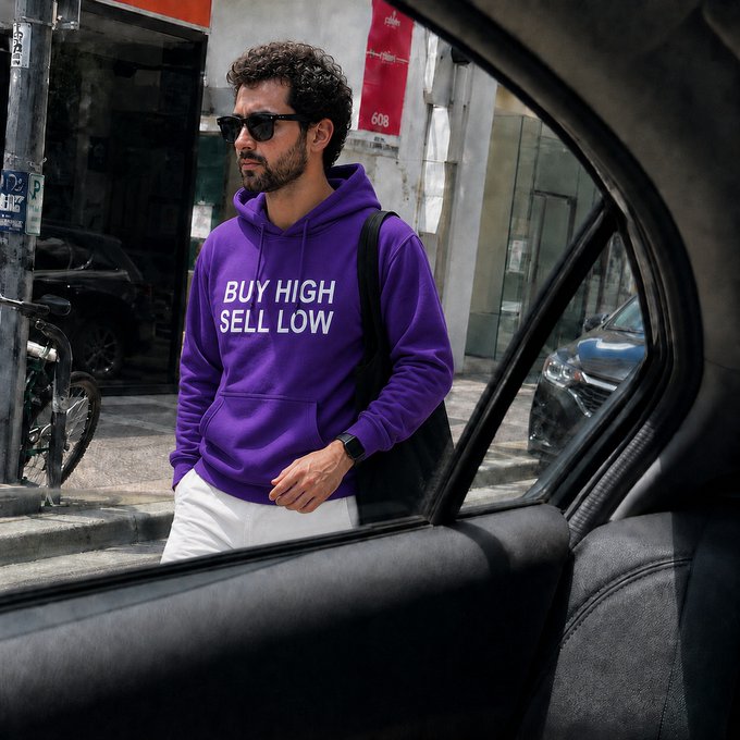 A man wearing a purple hoodie with the ironic phrase "BUY HIGH SELL LOW" is seen through a car window, embodying the classic trading mistake referenced in the post about bad habits traders leave behind.
