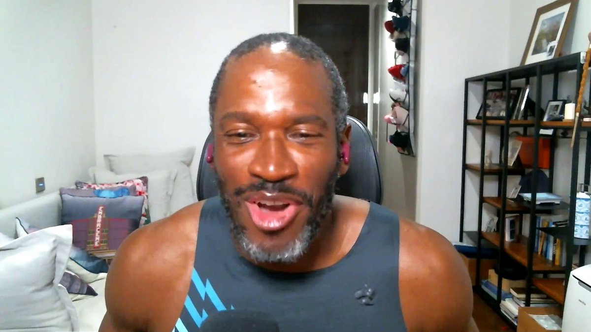 The image shows a man wearing a black tank top with blue text, sitting in front of a computer screen while making a funny face or showing an expression of laughter. The caption for the image reads "@CryptoHayes joins @jennsanasie on Markets Outlook to respond to the HYPE selloff drama, break down the new Fed chair's first move, and share his outlook on Uniswap, Solana, and the AI bubble".