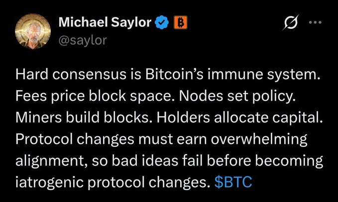 A screenshot of a tweet from Michael Saylor (@saylor) with a blue checkmark and Bitcoin logo next to his name, stating that hard consensus is Bitcoin's immune system, with fees pricing block space, nodes setting policy, miners building blocks, and holders allocating capital, while protocol changes must earn overwhelming alignment to prevent bad ideas from becoming harmful changes.