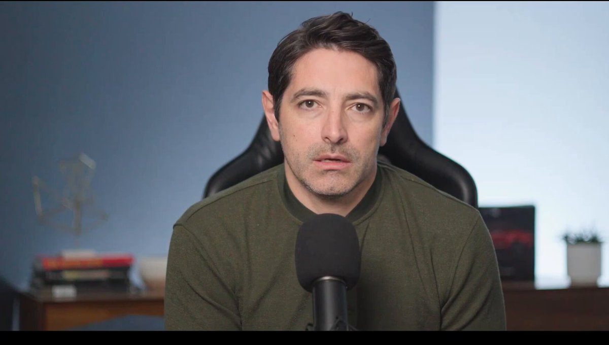 The image shows a man wearing a green shirt sitting at a desk with a microphone, possibly recording or broadcasting something. The background features a blue wall and a chair, suggesting that he might be in an office setting. There are several books scattered around him, indicating that he may be involved in some form of media production or content creation. The image also contains the text "Ethereum was not built to be a multibillion dollar enterprise. My take in 3 min, and how it relates to @CantonNetwork @CantonFdn $CC $ETH @ethereum". This implies that the man might be discussing or reviewing the concept of Ethereum, which is an open-source blockchain platform designed for secure transactions and smart contracts. The image could potentially be related to a podcast, blog post, or other media content about the cryptocurrency market or blockchain technology.