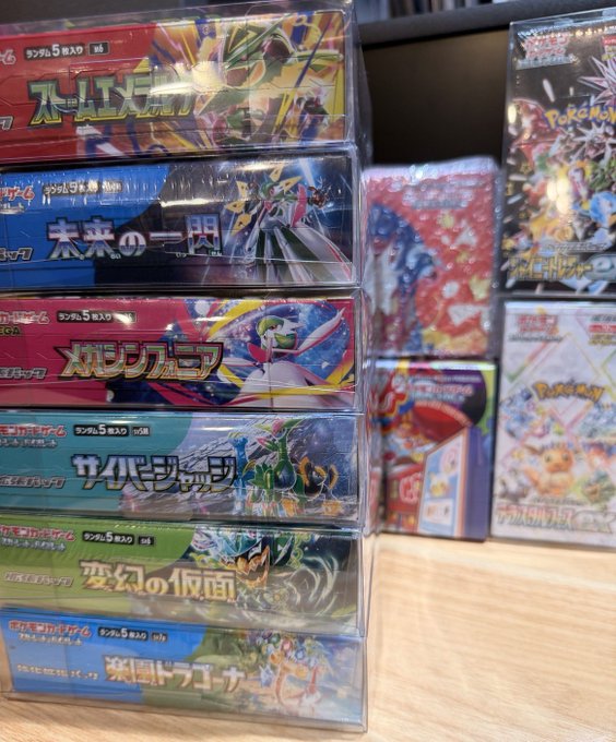 A stack of Japanese Pokémon trading card game booster boxes with Japanese text, displayed alongside other Pokémon card products.