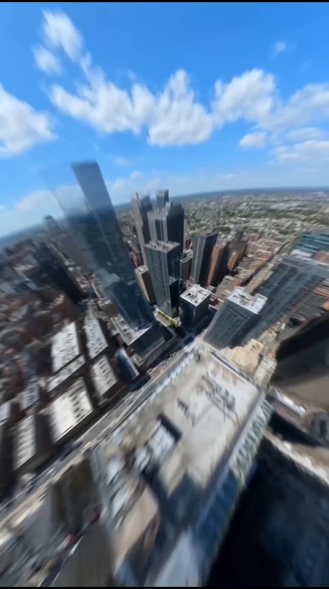The image shows an aerial view of a city with tall buildings, including skyscrapers that dominate the skyline. The perspective appears to be from above, providing a unique vantage point for observing the urban landscape below. In the foreground, there are two buildings prominently featured - one is a large glass building and the other is a smaller structure. A prominent feature in the image is a Bitcoin mining showroom located on the right side of the frame. The post also includes text that reads "🗽 New York just got a Bitcoin mining showroom ⚡₿".