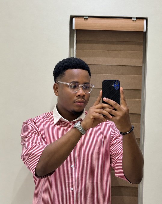 A young man in a red and white striped shirt takes a mirror selfie with his phone, complementing the cheerful "GM CT" morning greeting in the post.