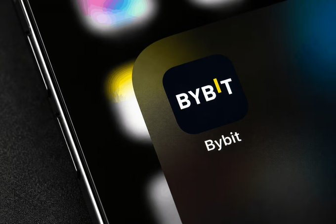 A close-up of a smartphone screen displaying the Bybit app icon, featuring the text "BYBIT" and "Bybit" on a dark background.