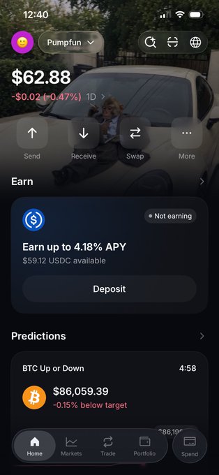 A screenshot of the Jupiter mobile app's home screen showing a Pumpfun token balance of $62.88 (down 0.47%) with Earn and Predictions sections, displaying a USDC APY offer of 4.18% and BTC price of $86,059.39. The image illustrates the new Jupiter UI redesign referenced in the post, showcasing the updated dark-themed interface with its reorganized home, markets, trade, portfolio, and send navigation tabs.