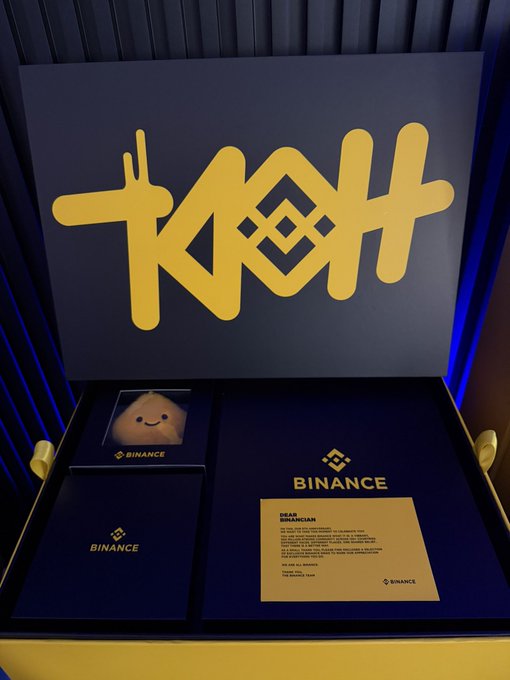 This image showcases a Binance care package, including a plush toy and a congratulatory letter, gifted to the user on Binance's 9th anniversary, as described in the accompanying post about a giveaway.