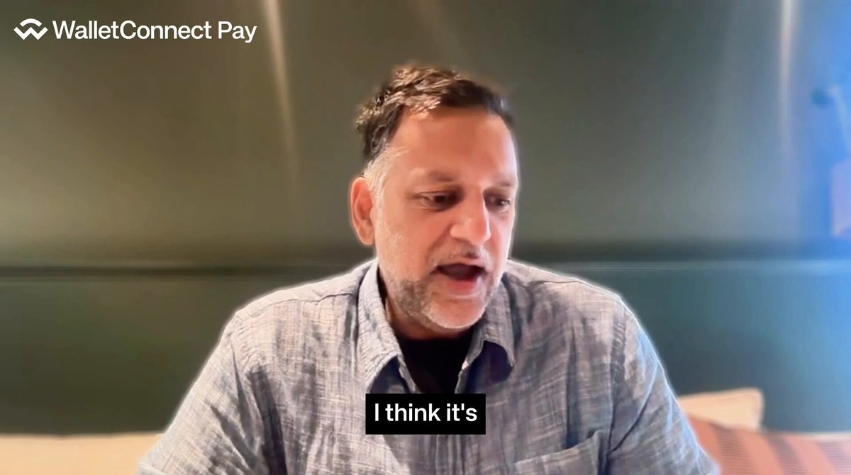 The image shows a man sitting down with his mouth open while talking into a microphone. The background appears to be a green wall or a tablecloth. There is also text visible, which reads "I think it's". This suggests that the man might be discussing something related to the content of the post on social media, possibly about the benefits and advantages of using Solana as a payment method for businesses.