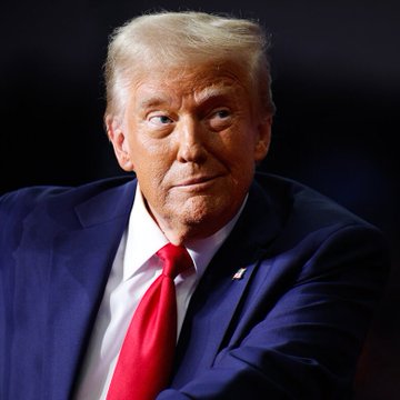 The image shows Donald Trump wearing a dark navy suit with a red tie and an American flag lapel pin, with a serious expression. The caption relates to the breaking news that Trump has agreed to ethics provisions in the CLARITY Act, including divesting substantial crypto interests, as part of a revised Senate Republican offer ahead of an upcoming vote.
