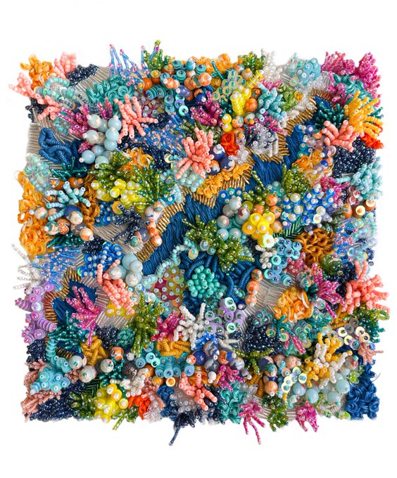 A colorful, highly textured mixed-media artwork featuring an abundance of vibrant coral-like shapes, beads, and intricate sculptural details in various shades of pink, blue, green, yellow, and white.