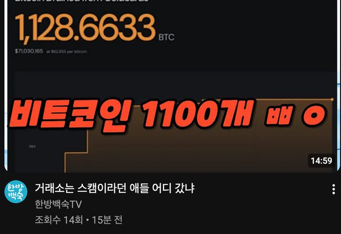 The image is a YouTube thumbnail showing a Bitcoin wallet balance of 1,128.6633 BTC (worth ~$71,030,165) with bold Korean text reading "비트코인 1100개 보유" (Holding 1,100 Bitcoin) from the channel "한방백수TV" (Jobless TV). 

The thumbnail supports the post's argument about cryptocurrency security by displaying a massive self-custodied Bitcoin balance, visually reinforcing the author's point that trusting exchange-generated wallets is foolish compared to personally rolling dice or flipping coins to generate a mnemonic seed phrase.