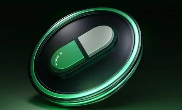 A 3D rendered green and silver capsule icon on a dark background, commonly associated with pharmaceutical or medical imagery.